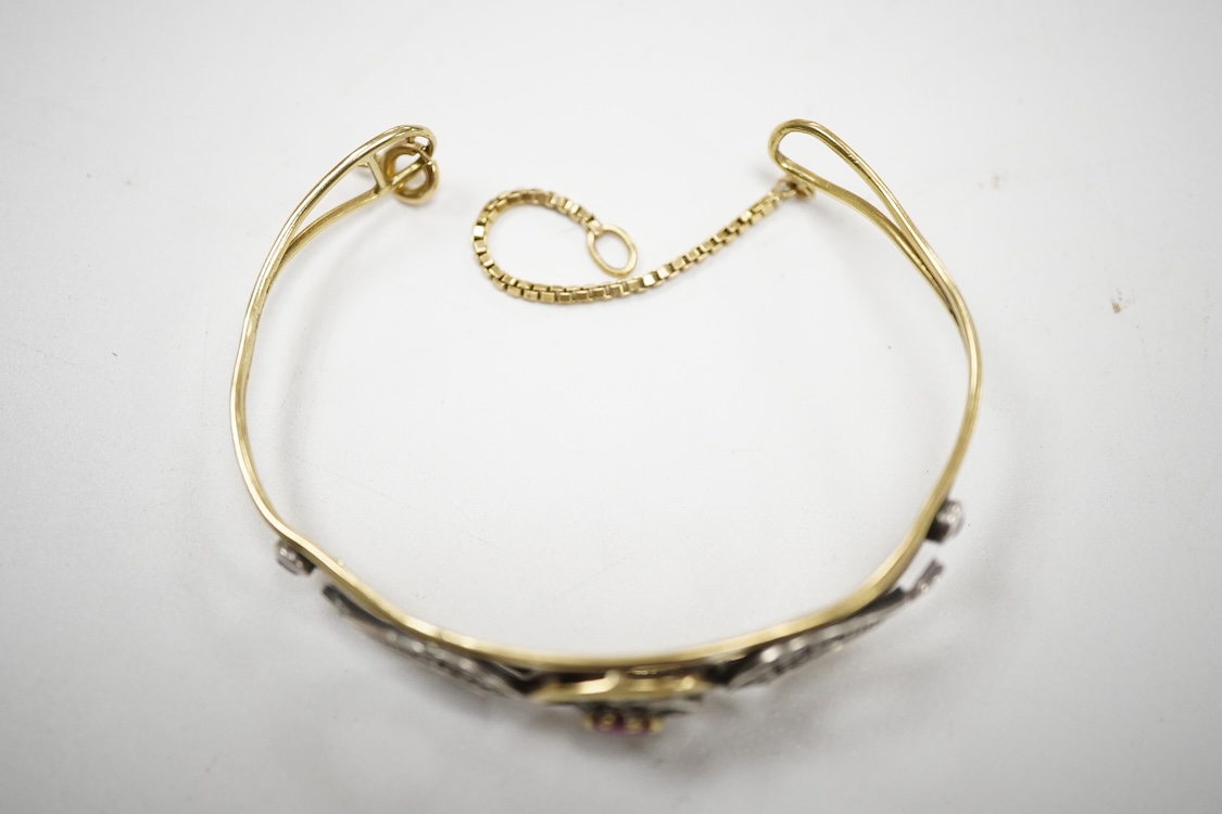 An Italian 18k and white metal, ruby and diamond cluster set bangle, with safety chain, gross weight 10.1 grams.